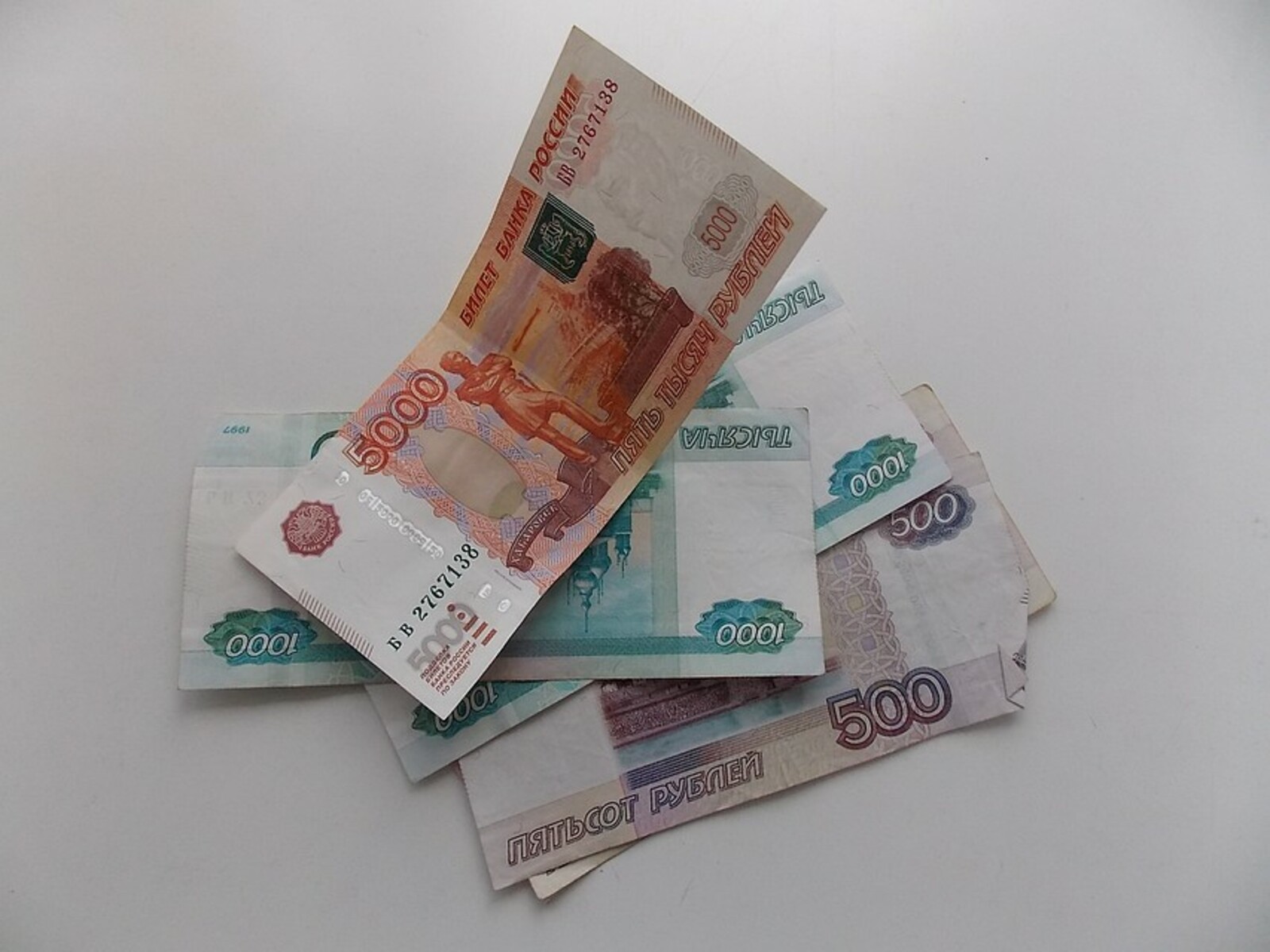 Восемь тысяч пять сот. Деньги рубли. Немного денег в руках. Небольшая пачка денег. Деньги в наличке на столе.